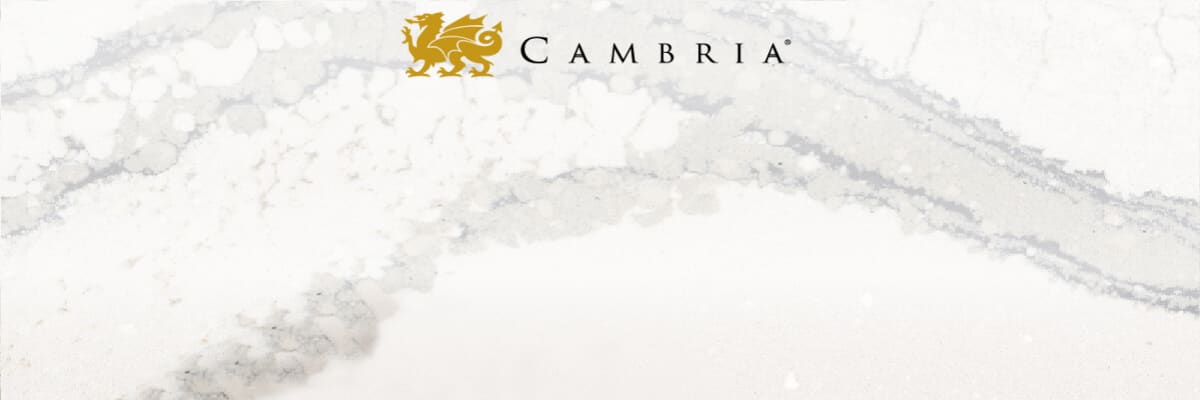 White and gray marbled surface with a small golden dragon emblem above the word Cambria in a refined serif typeface centered at the top.