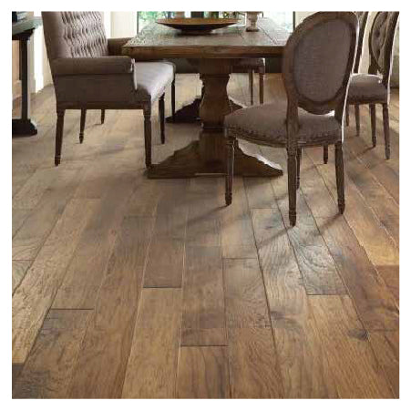 Dining area with a wooden table and cushioned chairs placed on warm-toned hardwood flooring featuring natural grain patterns.