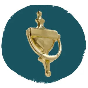 Polished brass door knocker with a classic urn shape and rounded details displayed against a textured teal circular background