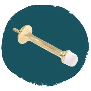 Brass-finished door stop with a white rubber tip and screw attachment, displayed against a solid dark teal background for home improvement use.