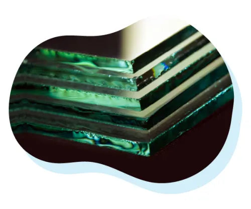 Close-up view of several stacked sheets of clear glass with polished edges, shown against a dark background.