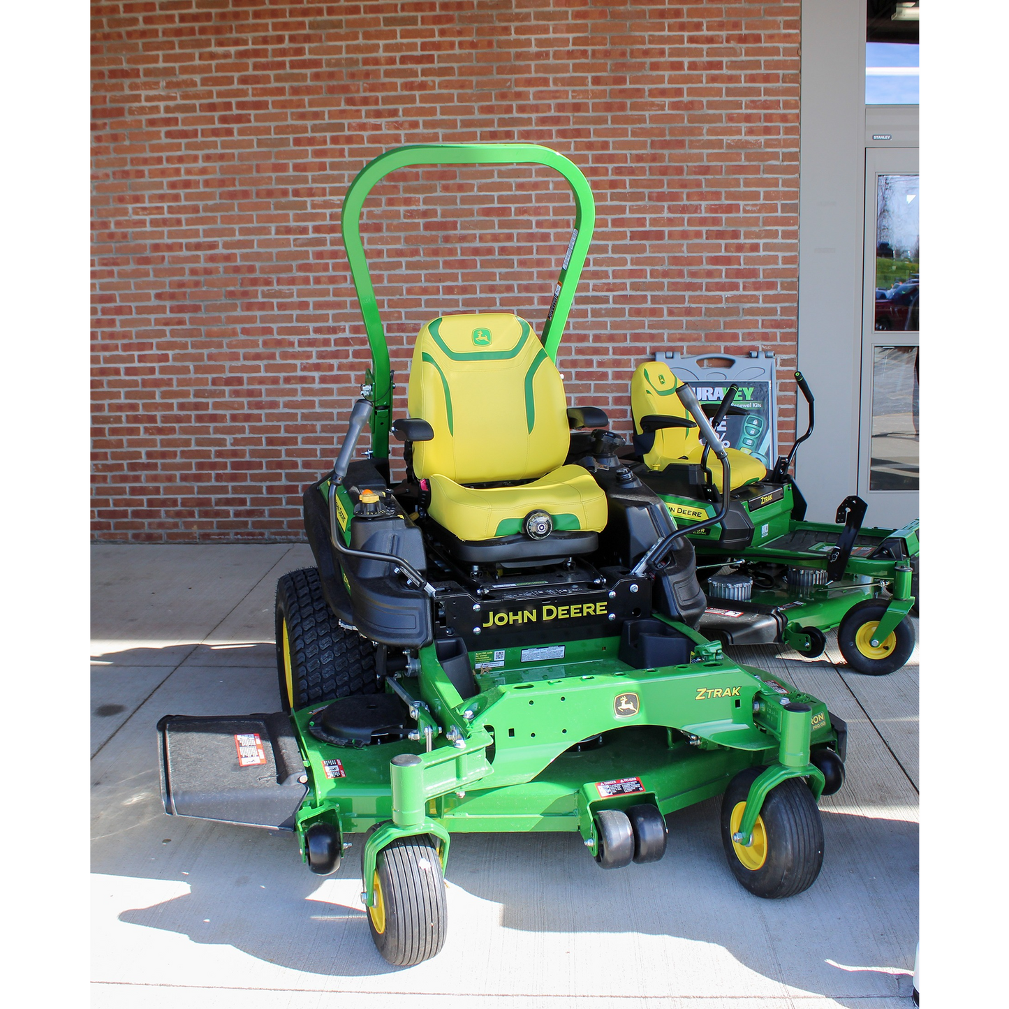 Green John Deere zero turn mower with yellow seat and 60-inch deck, displayed outdoors at Hartville Hardware in the lawn mowers and zero turn lawn mowers section.