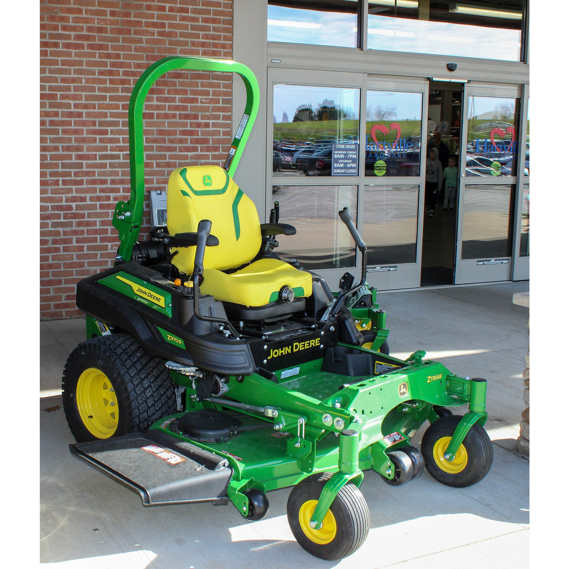Green and yellow John Deere zero turn mower with 60-inch deck and commercial-grade build, displayed outside Hartville Hardware in the lawn mowers section.