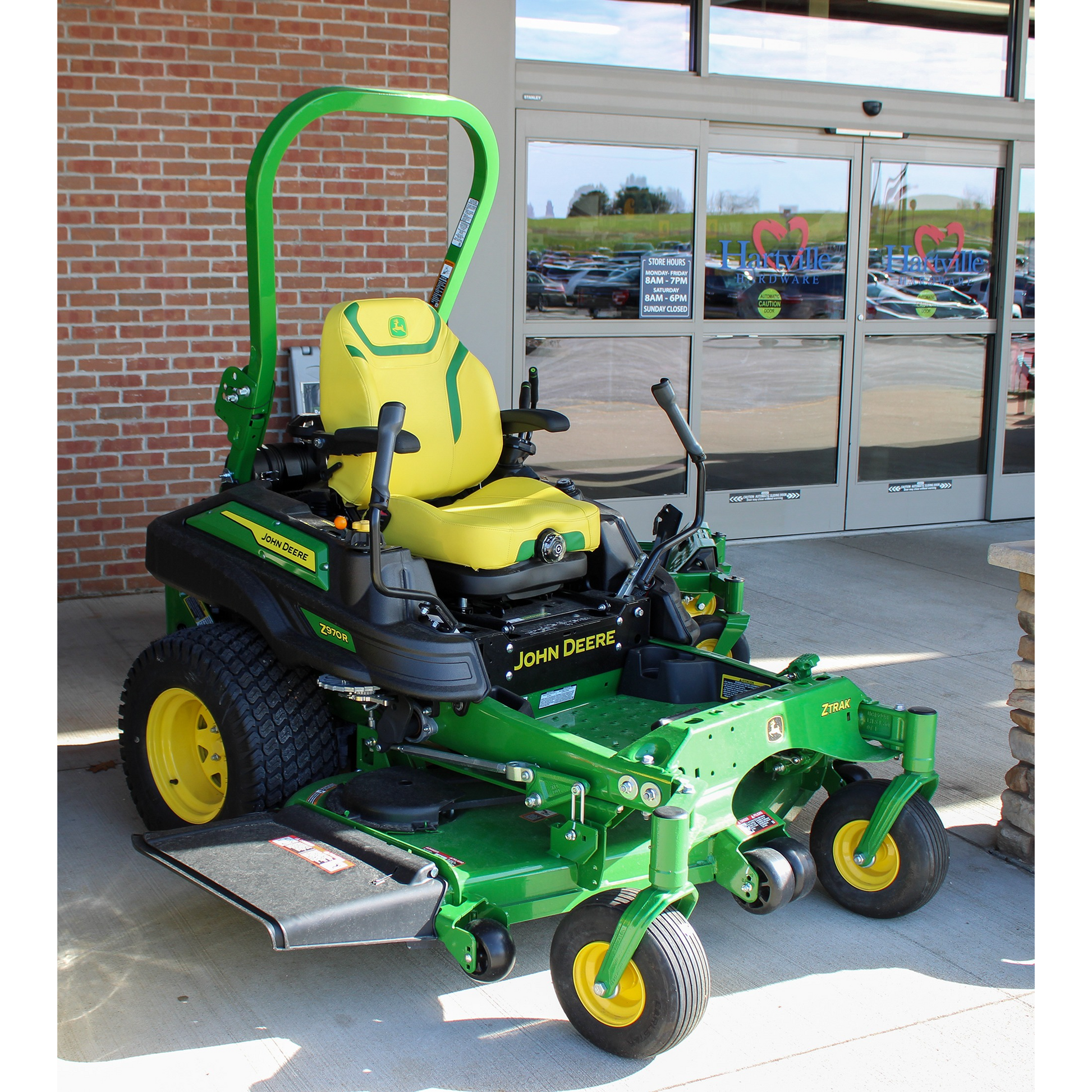 Green and yellow John Deere zero-turn mower with 72-inch deck and ergonomic operator seat, positioned outside Hartville Hardware in the lawn mowers and outdoor power equipment section