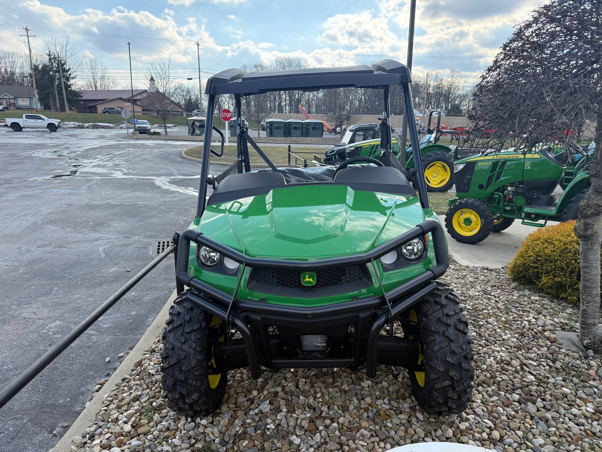 Green John Deere mid-size crossover utility vehicle with rugged tires and protective roll cage, part of John Deere UTVs at Hartville Hardware.