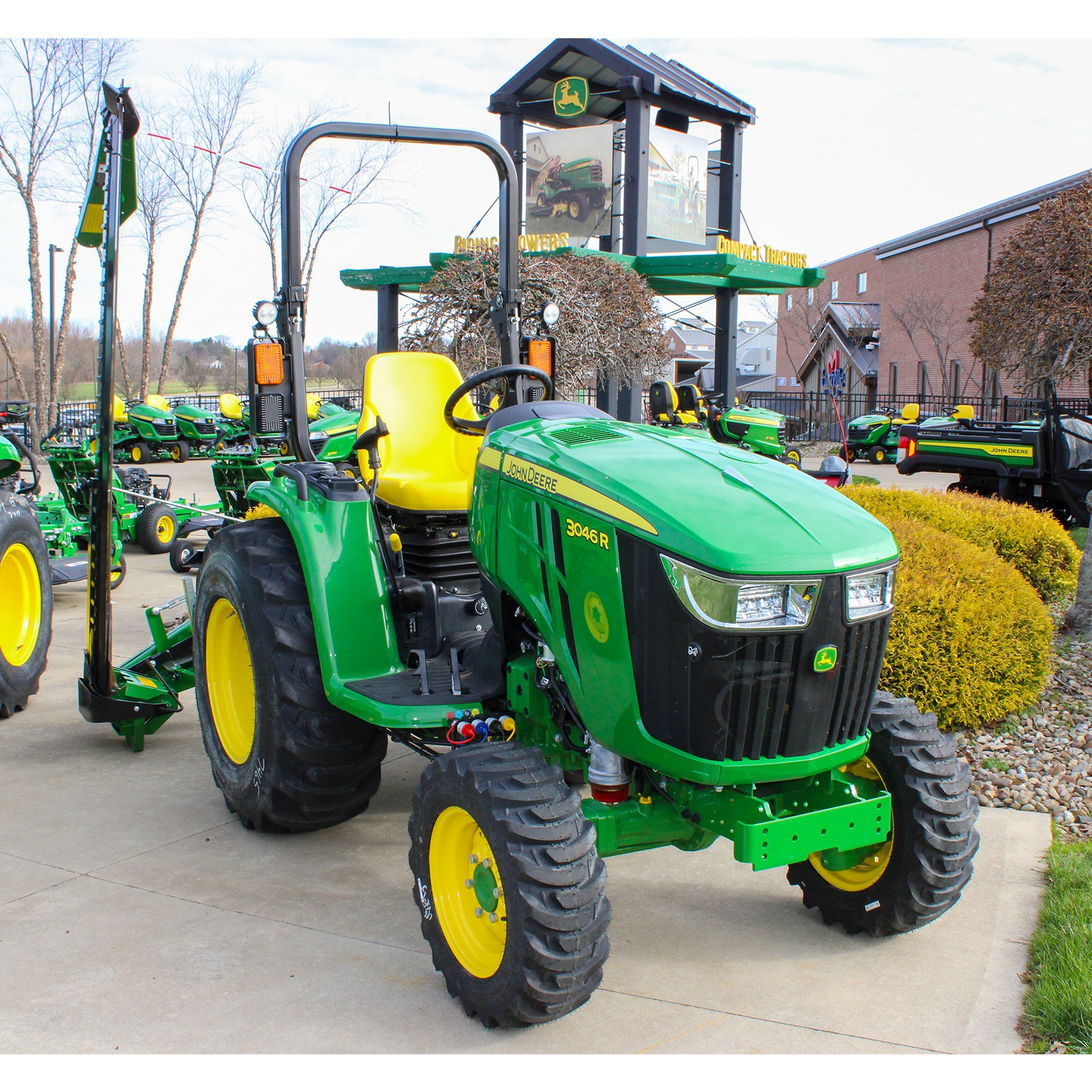Green John Deere 3046R compact utility tractor with yellow seat and rugged tires displayed outdoors in the Outdoor Power Equipment section at Hartville Hardware.