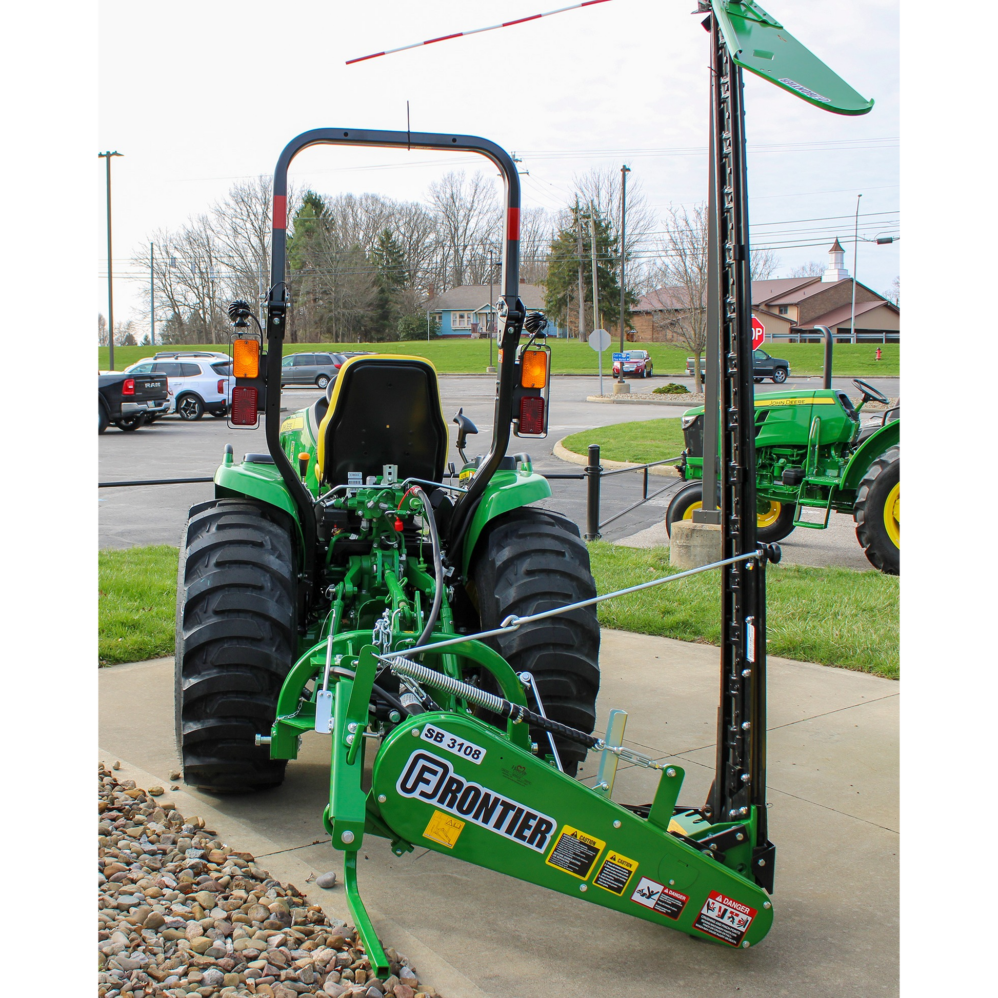 Rear view of a green John Deere 3046R compact tractor equipped with a Frontier SB3108 implement, displayed outdoors at Hartville Hardware in the Outdoor Power Equipment section.
