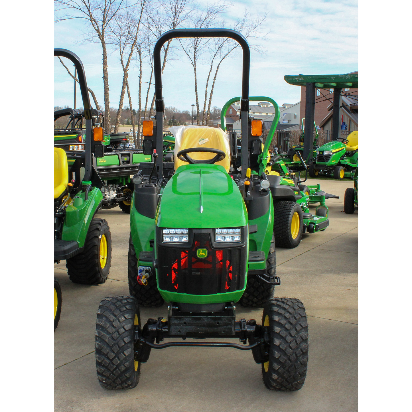 Green compact tractor with LED headlights and rollover protection, designed for versatile use in outdoor power equipment and lawn and garden tasks.