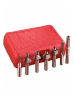 Set of copper-colored router bits with various shapes arranged in front of a red plastic case, used for woodworking and home improvement tasks.