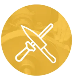 White outline of a knife being sharpened on a whetstone, set against a warm yellow circular background with faint workshop details.