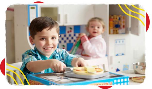 Two young children engaging in imaginative play in a bright kitchen setting, using toy cooking utensils and food items.