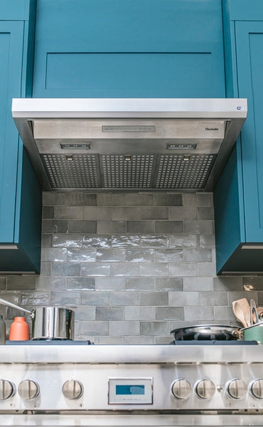 Stainless steel 36-inch custom insert range hood with built-in lighting and mesh filters in kitchen appliance collection