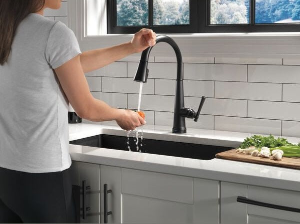 Matte black single handle pull-down kitchen faucet with touch activation in modern kitchen sink setting for home improvement collections