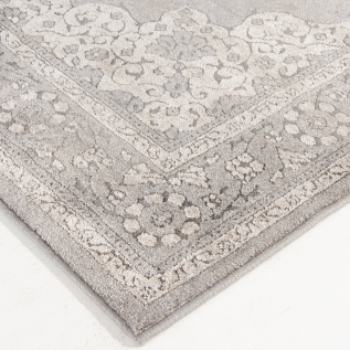 Close-up of a textured gray area rug with subtle floral and ornamental border pattern for stylish home flooring