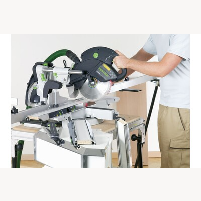 Person operating Festool sliding compound miter saw KS 120 REB in workshop among power tools and saws collections