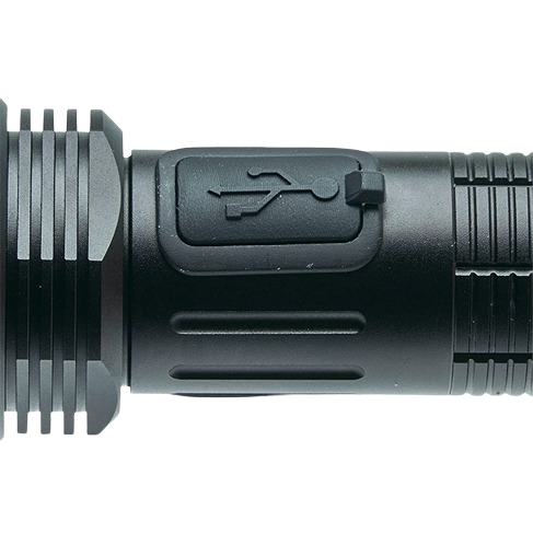 Close-up of black tactical flashlight USB charging port cover with grooved metal body for tools and home use