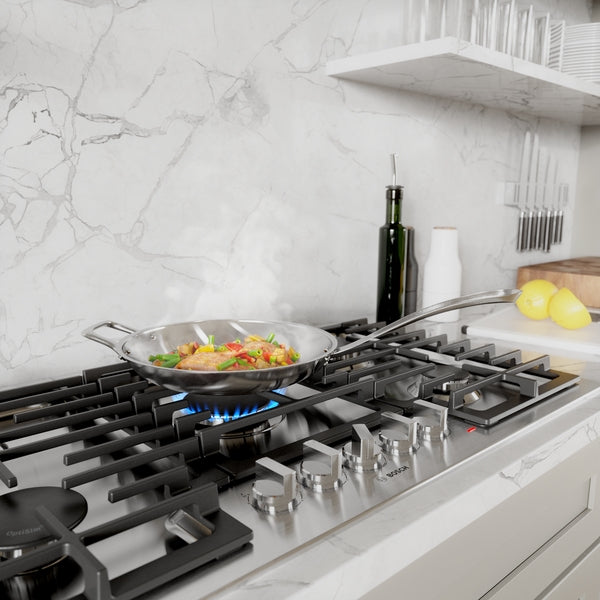 Elegant gas cooktop with stainless steel knobs cooking a colorful sauté in a modern kitchen setting