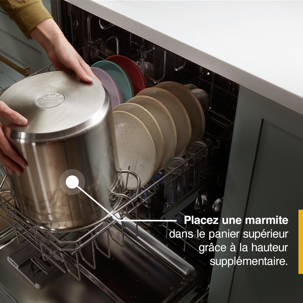 Loading a large stainless steel pot into the top rack of a dishwasher with plates inside, kitchen appliances collection
