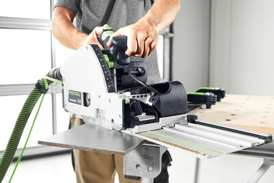 Person guiding Festool plunge cut track saw with 75-inch guide rail for precise splinter-free cuts in home improvement tools collection