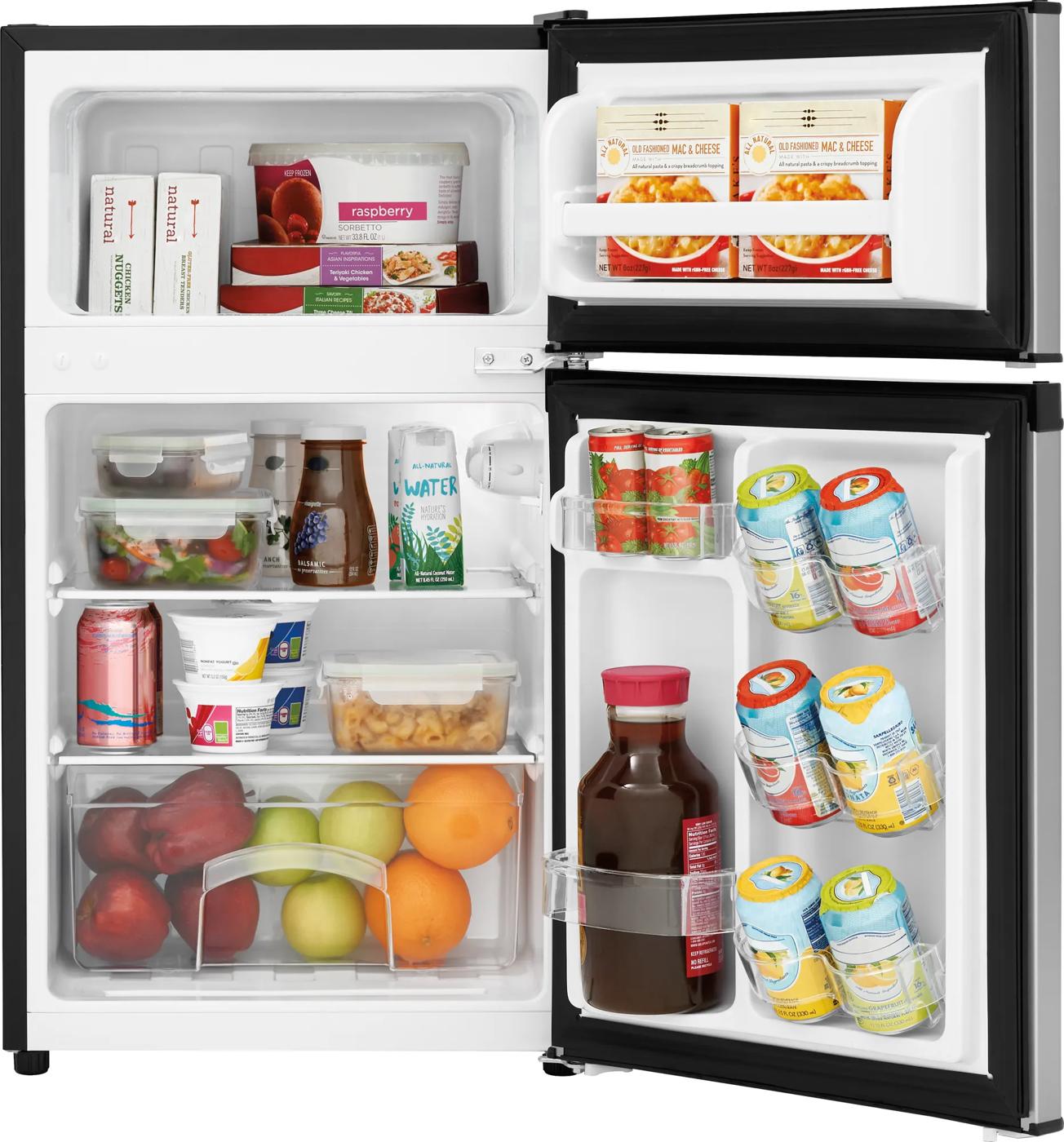 Open compact refrigerator in kitchen appliances collection with beverages, snacks, and fresh fruit inside shelves and door compartments