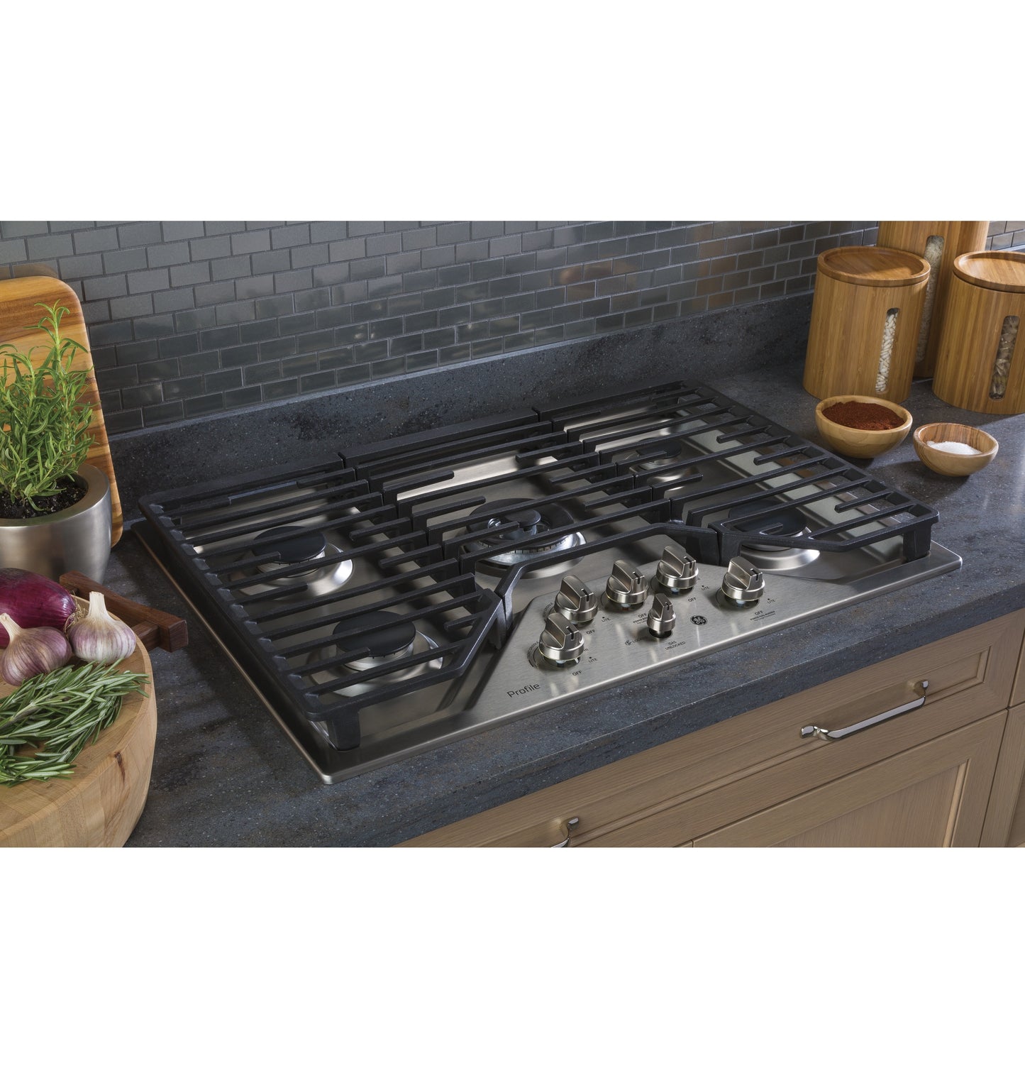 Built-in stainless steel gas cooktop with five burners and control knobs installed in modern kitchen countertop