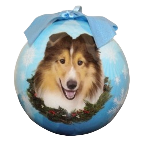 Blue Christmas ornament featuring a smiling Sheltie dog with a holiday wreath and bow decoration