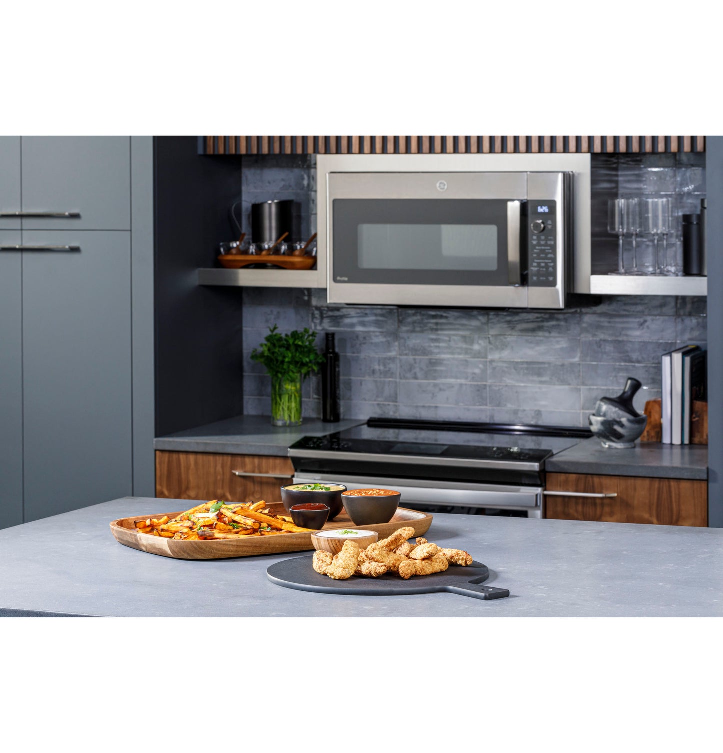 Stainless steel over-the-range microwave with digital controls above modern stove in sleek kitchen setting