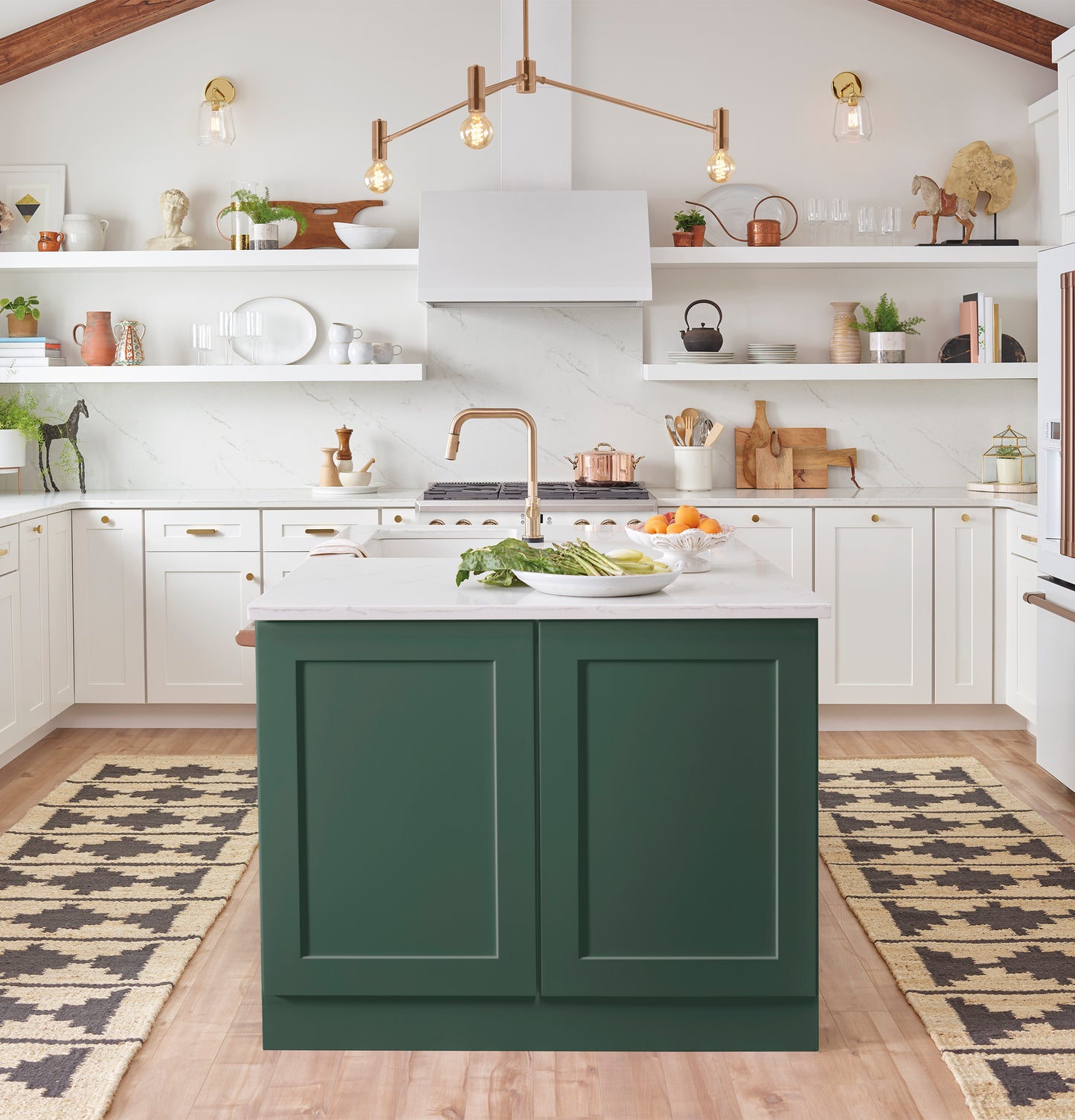 Bright kitchen with white cabinetry, green island, pendant lighting, and a sleek white over the range hood above cooktop