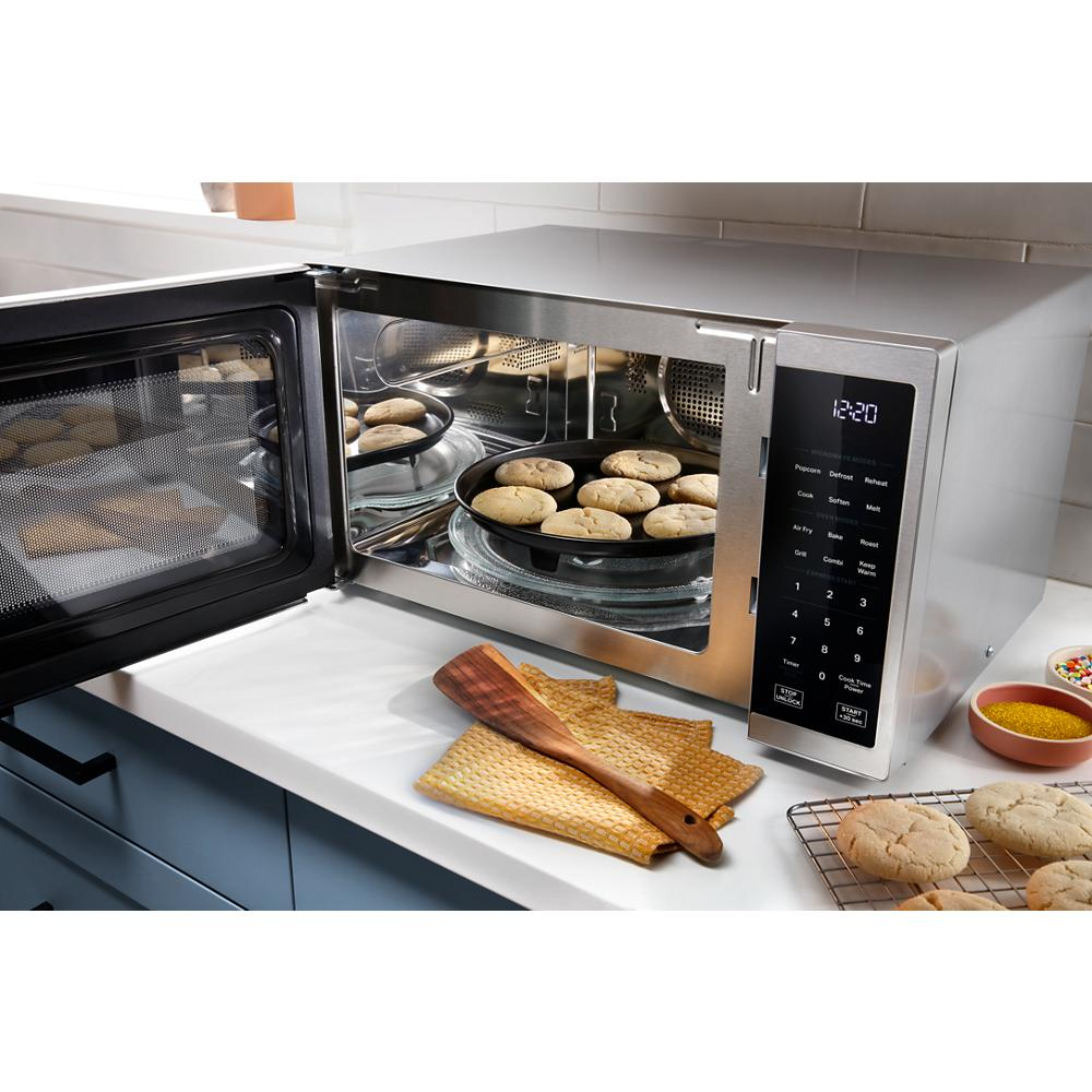 Stainless steel multifunctional countertop microwave with air fry cooking mode baking cookies in modern kitchen setting