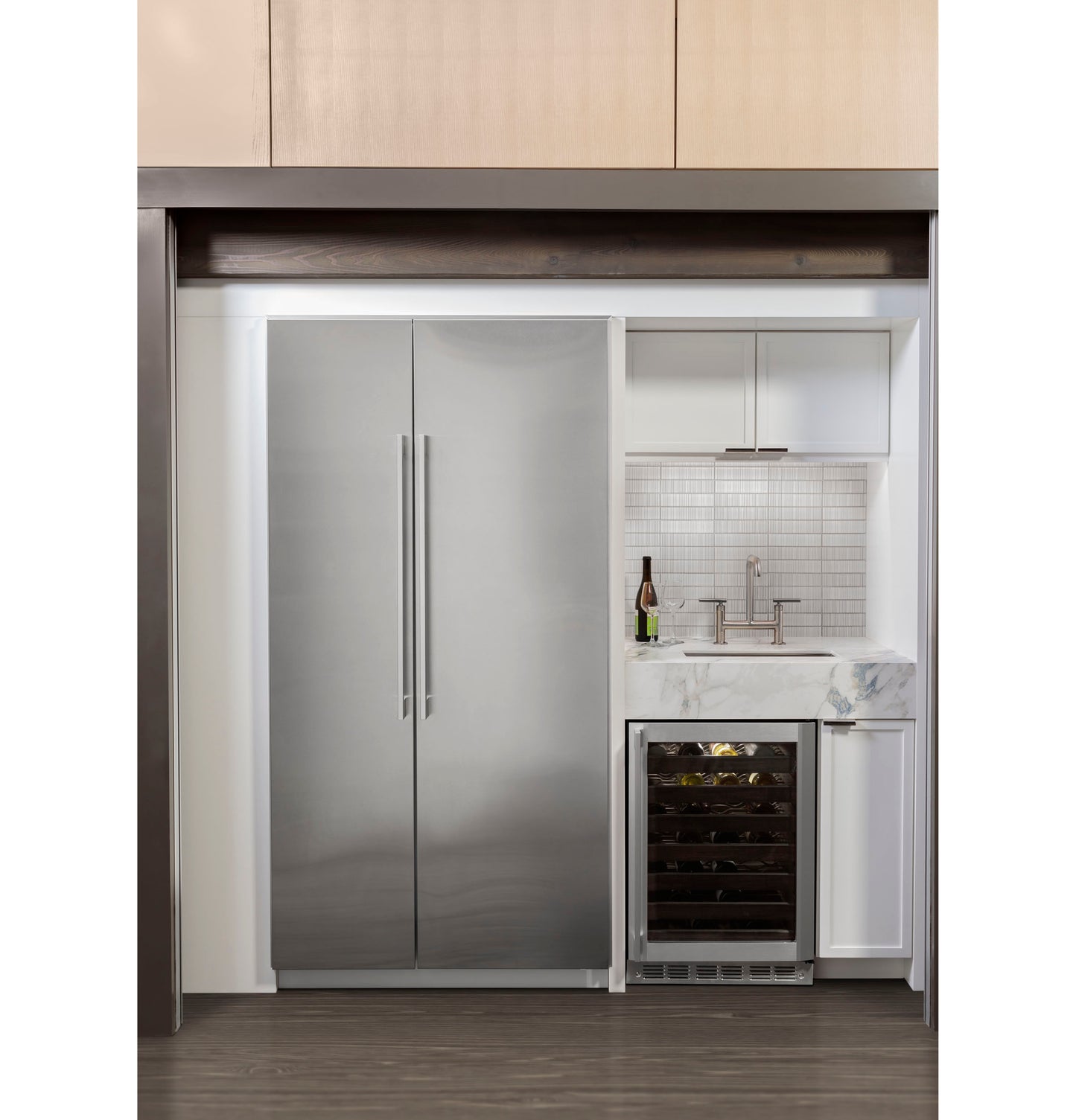 Built-in stainless steel integrated freezer column with tall vertical handles in a modern kitchen appliance setup