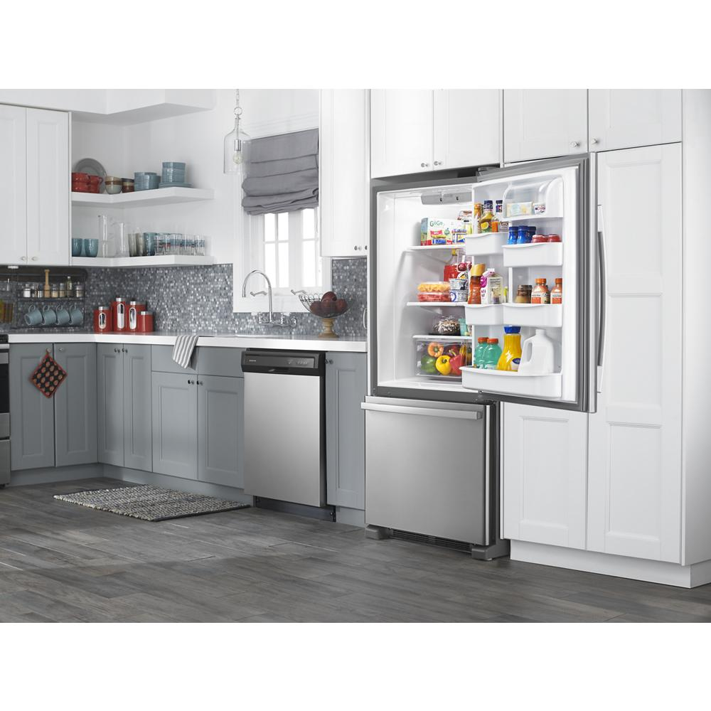 Modern kitchen featuring a stainless steel bottom-freezer refrigerator with door open, showing organized groceries and beverages