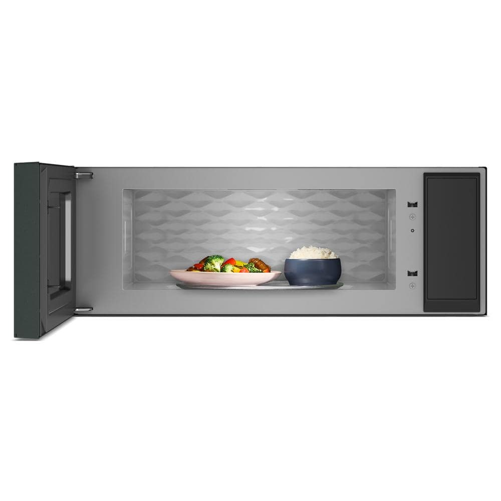 Interior view of a stainless steel microwave with open door showing dishes inside for kitchen appliances collection