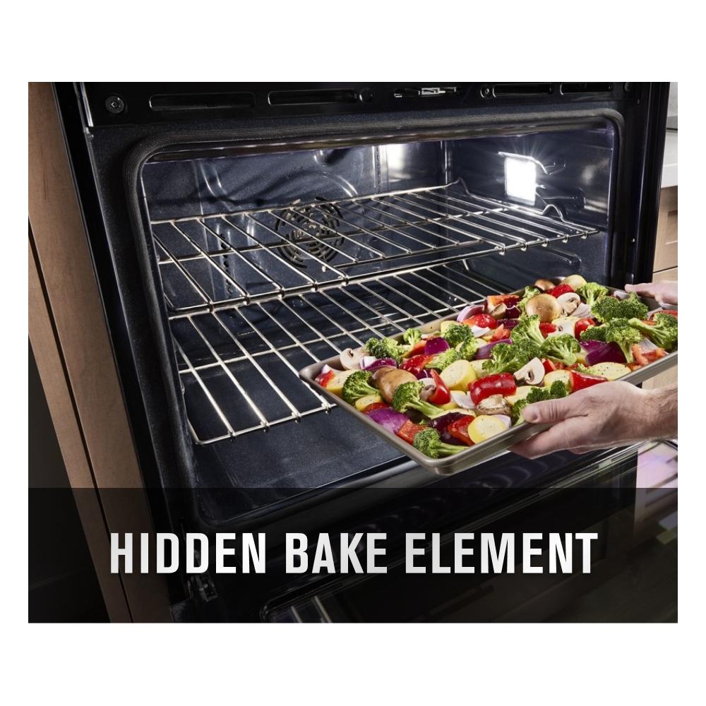 Person placing a tray of colorful vegetables into a stainless steel double wall oven from kitchen appliances collection