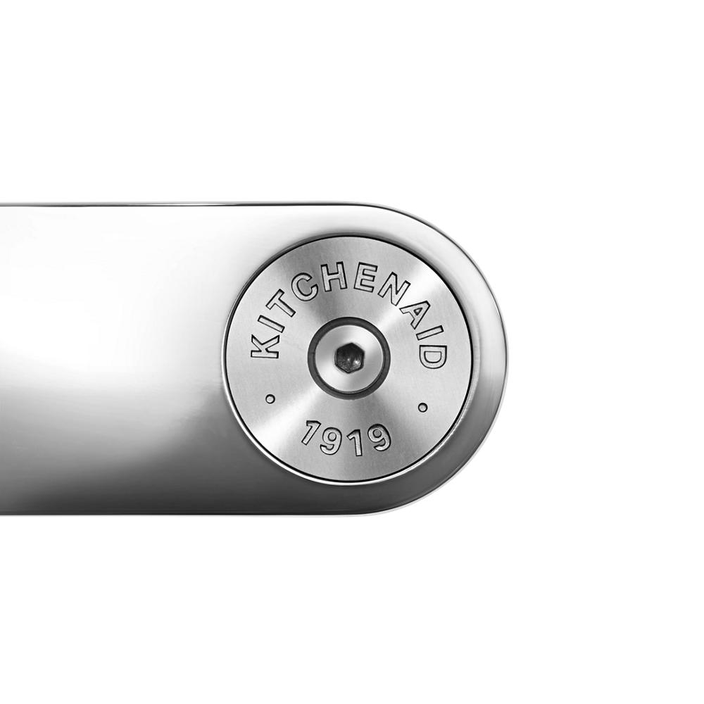 Close-up of stainless steel handle end with KitchenAid 1919 engraved emblem on kitchen appliance accessory