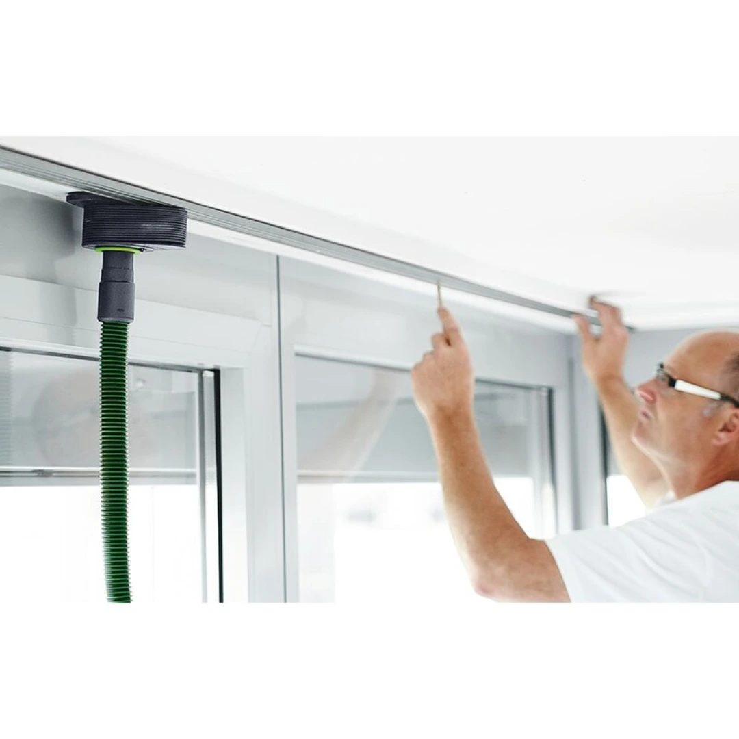Man using Festool dust extractor accessory to hold molding in place during home improvement woodworking project