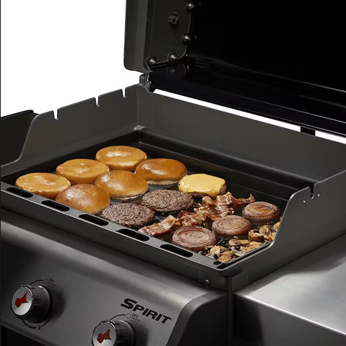 Full-sized flat top griddle cooking burgers, bacon, onions, mushrooms, and buns on a gas grill for outdoor living and kitchenware.