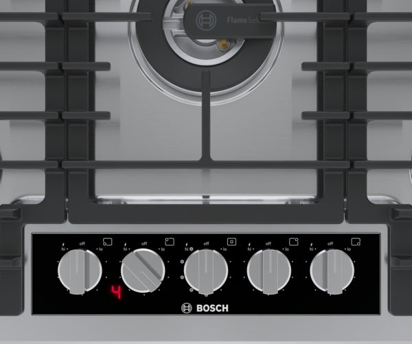 Close-up of Bosch stainless steel gas cooktop control panel with five knobs and digital flame adjustment display
