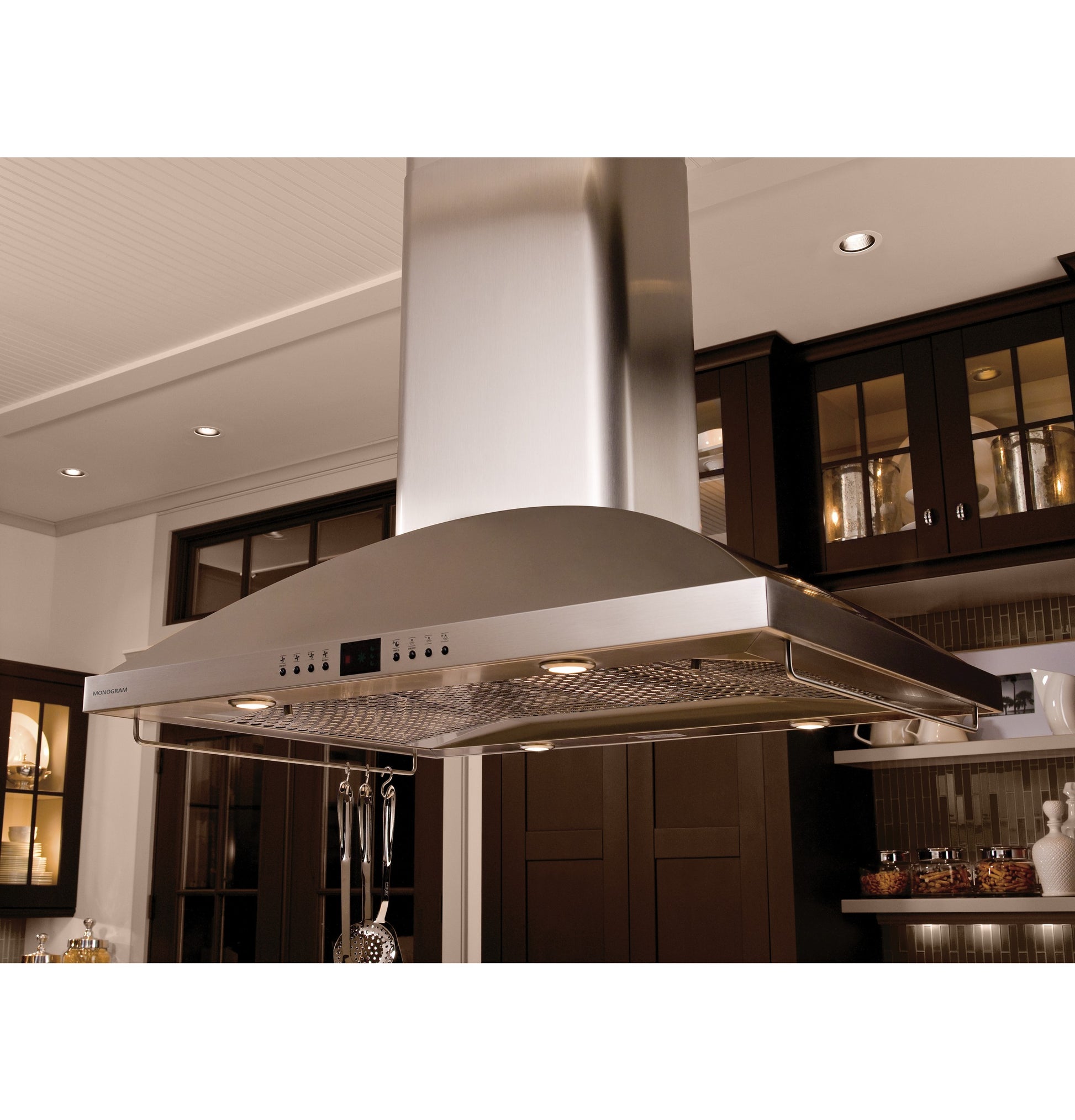 Stainless steel island range hood with curved canopy, digital controls, and built-in lighting in modern kitchen appliances collection