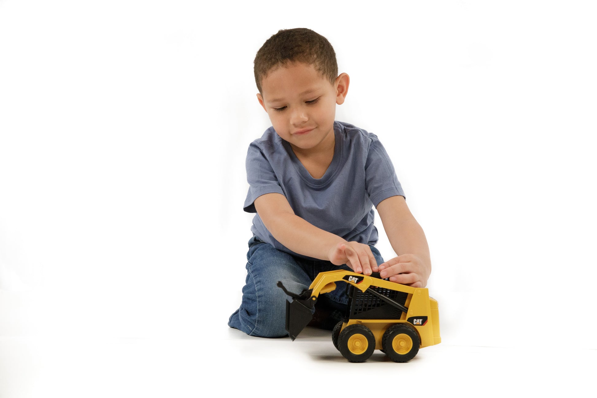 Young child engaging with a detailed Bruder CAT skid steer loader toy for imaginative construction play