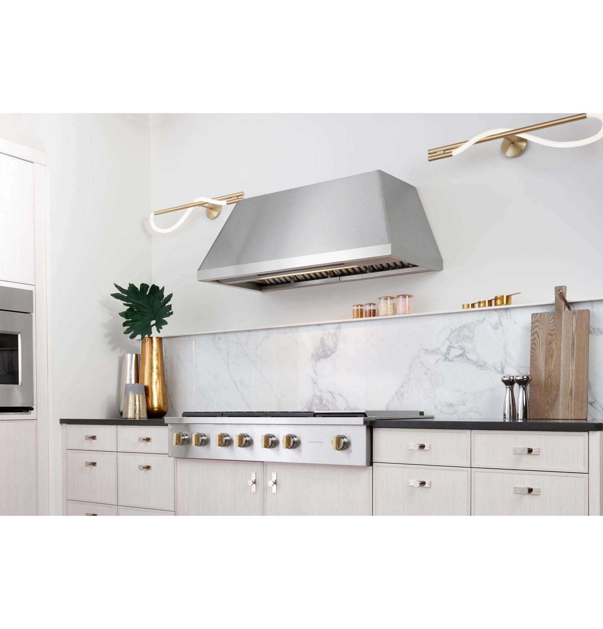 Modern kitchen featuring stainless steel professional gas rangetop with six burners and gold-tone knobs in Cooktops collection