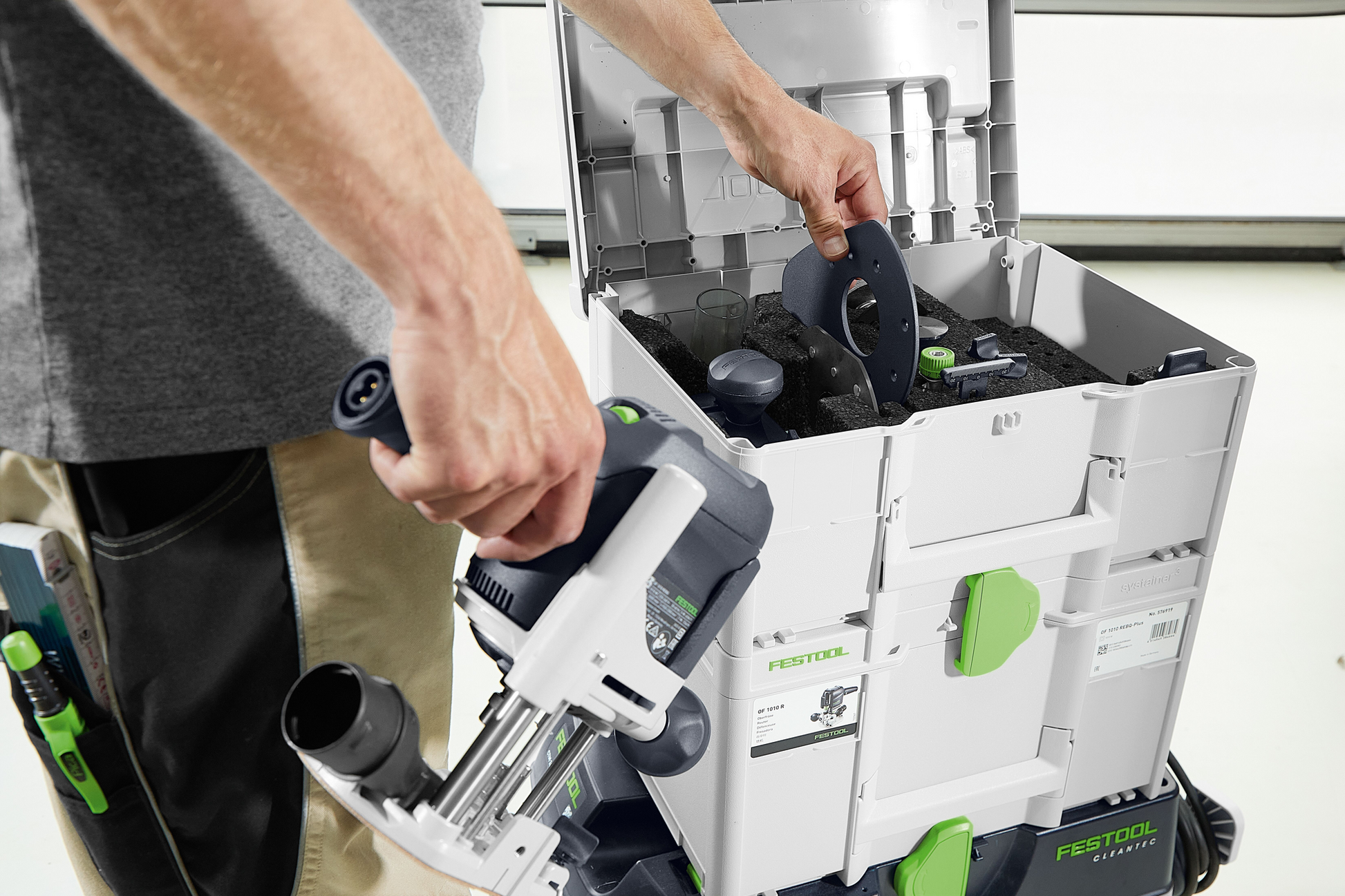 Person organizing routing accessories inside a Festool Systainer for woodworking tool storage and home improvement tasks