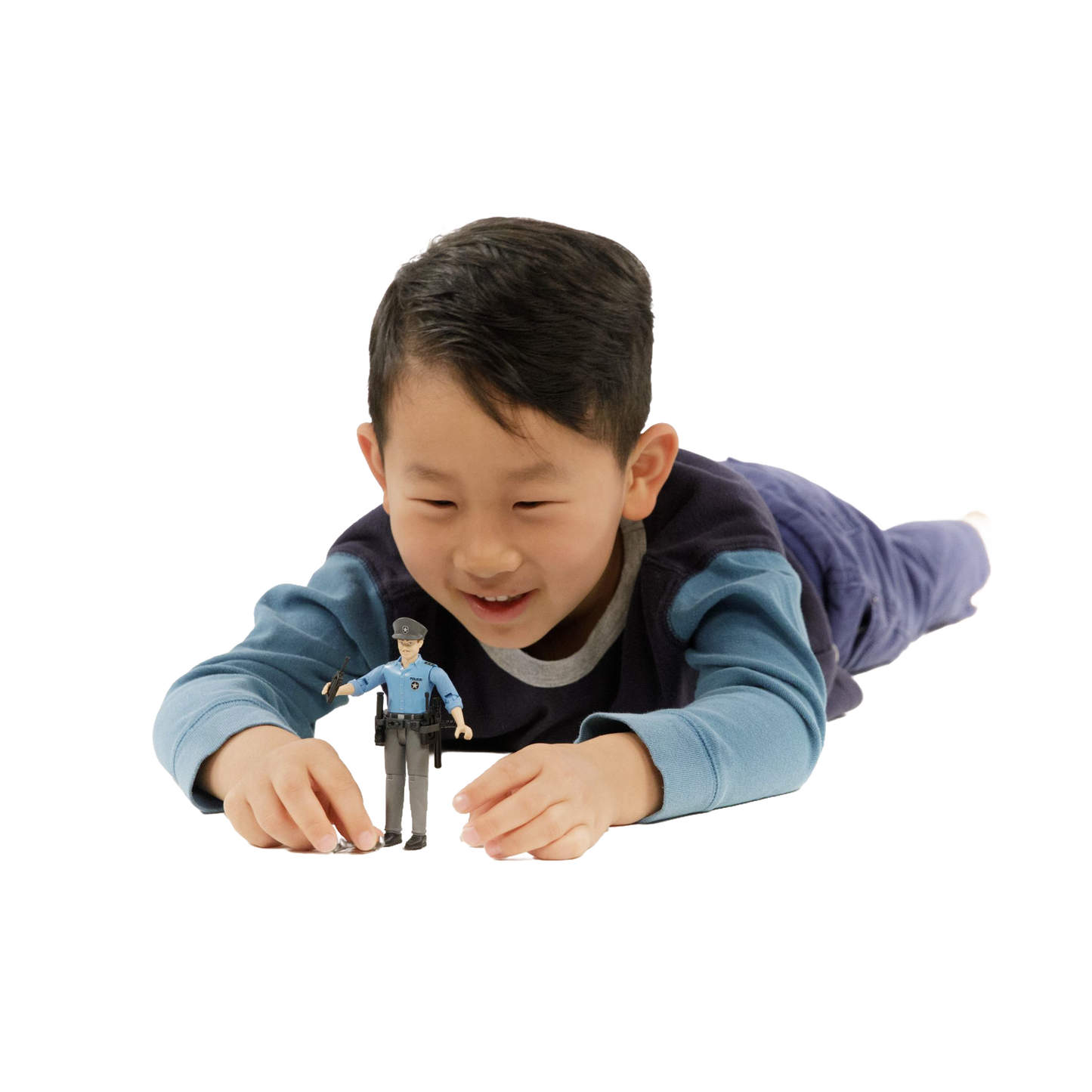 Young boy lying down playing with a light skin policeman action figure from Bruder Toys in Toys & Games collection