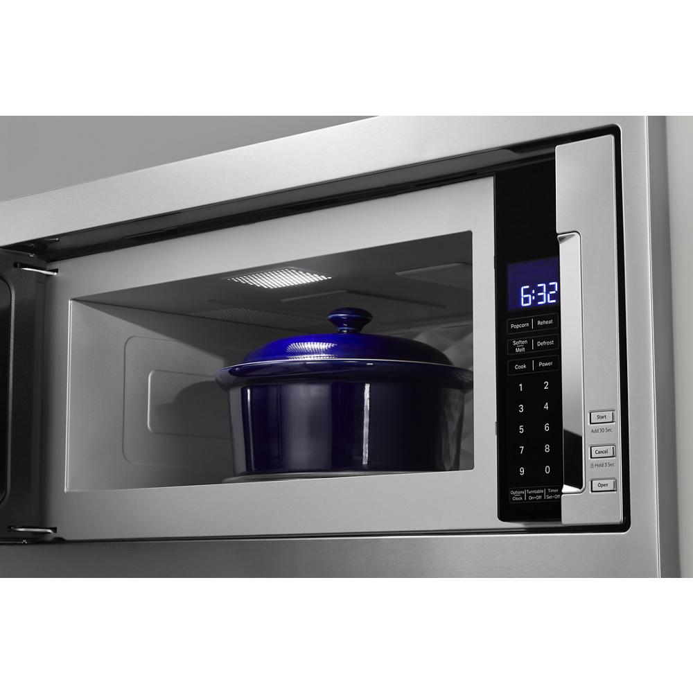 Built-in microwave with digital control panel and blue ceramic pot inside, part of KitchenAid appliances collection
