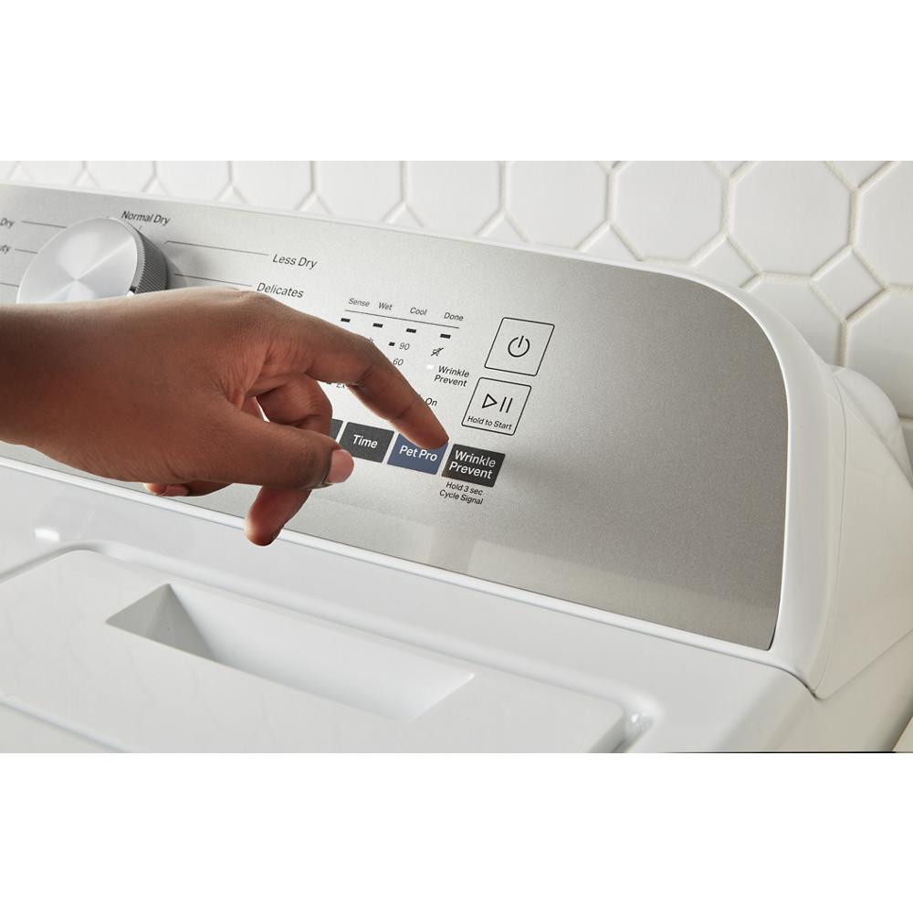 Hand selecting Pet Pro option on silver control panel of top load electric dryer in laundry area with white tiled wall