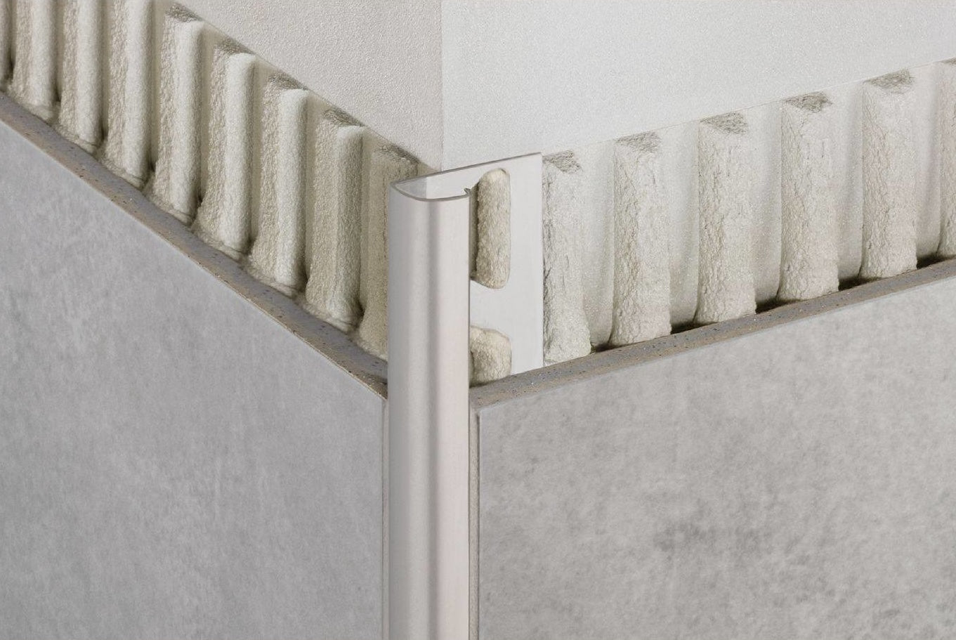 Brushed nickel edge protector installed on tile corner for durable finishing in Flooring and Tile collections under $50