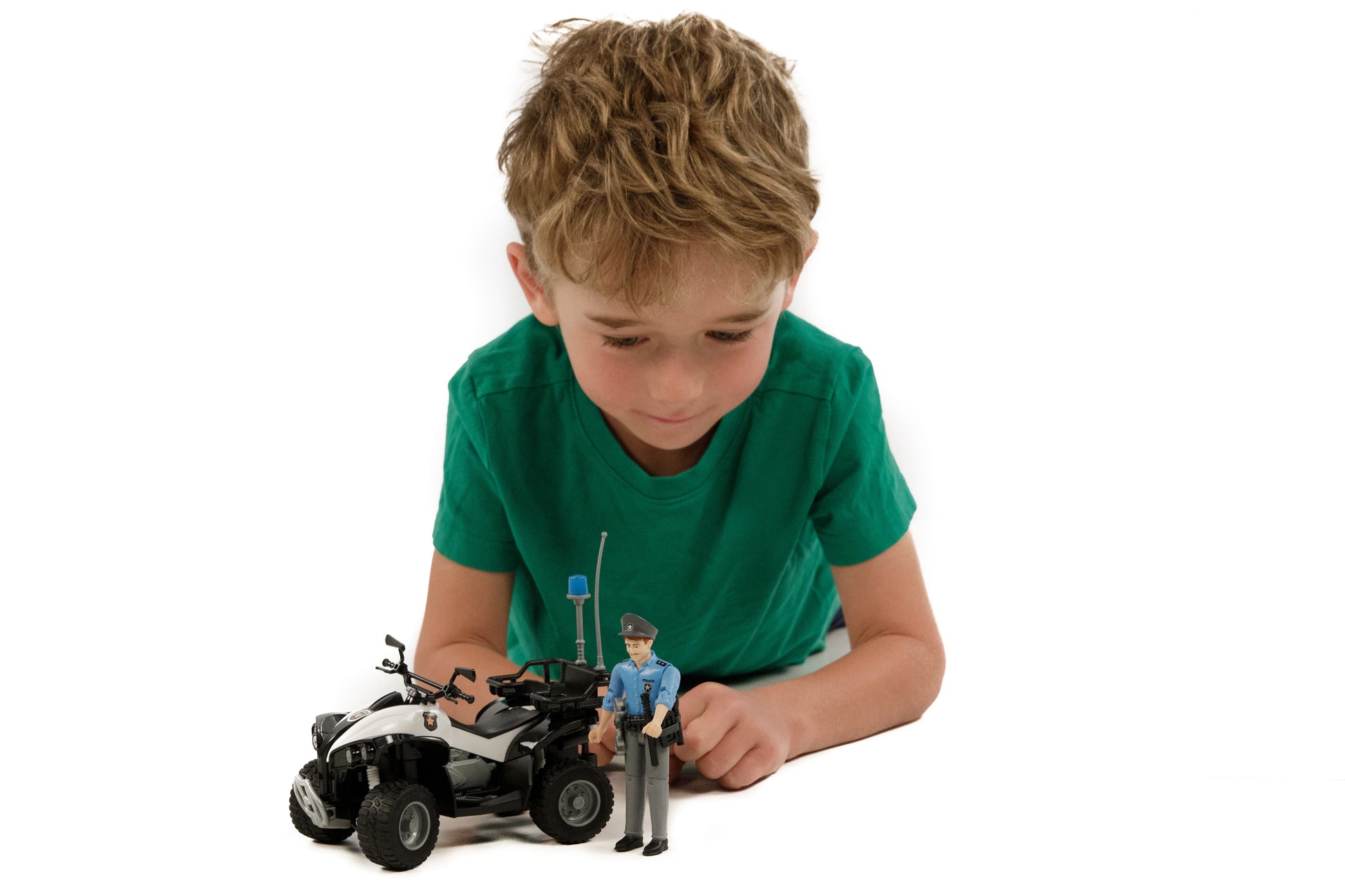 Young boy playing with a detailed police quad toy and light skin officer figure from Bruder Toys collection