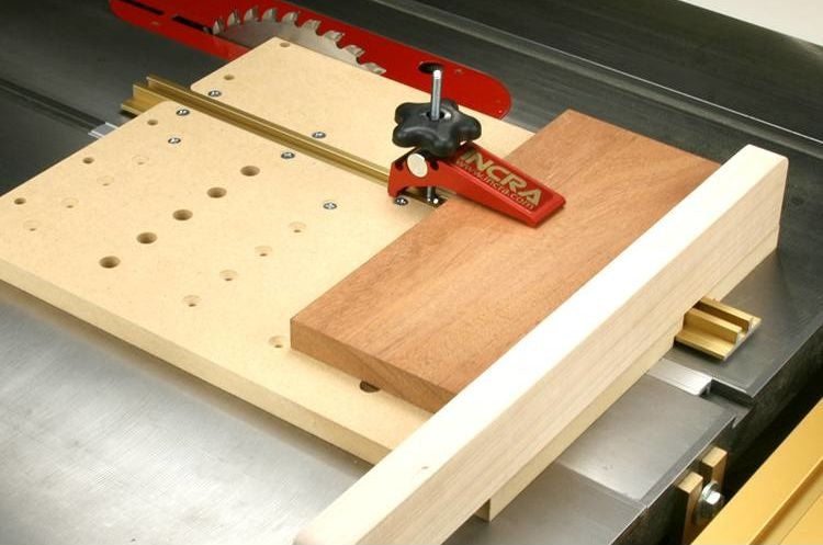 Red woodworking clamp with black star knob securing wood on workbench for measuring and clamping tools under $100 collections