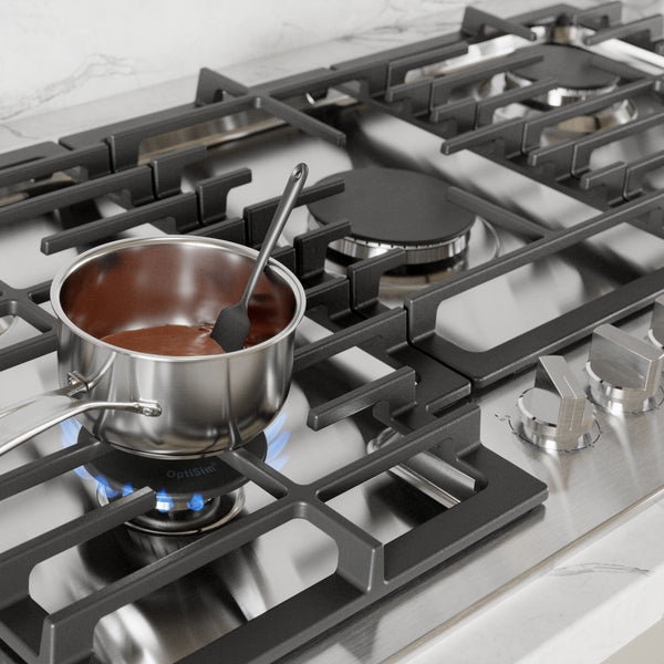 Stainless steel gas cooktop with blue flame heating a sauce in a pot featuring sturdy cast iron grates from Bosch Cooktops collection