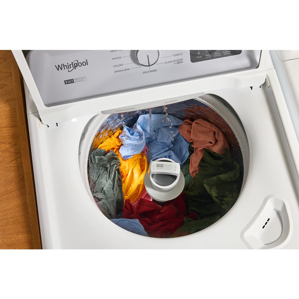 Top load washer with colorful clothes inside drum and 2-in-1 removable agitator in home appliance setting