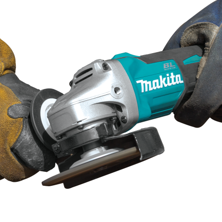 Makita cordless brushless angle grinder held by gloved hands for tools and home improvement tasks